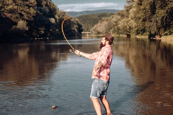 Heureux pêcheur barbu dans l'eau. Pêche sur le lac le matin. Partie pêcher. Pêcheur avec canne et poisson. Mettre en place tige avec crochet ligne plombs. Donner votre passe-temps . — Photo