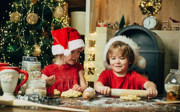 Playful holiday bakers. Two cute boys with santa hat. Milk and cookies for Santa Claus. Cookie on Christmas Eve as a thank Santa gift for leaving presents to a grateful boy or girl. — Stock Photo, Image