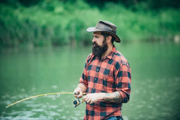 Passatempo masculino. Homem à beira do rio desfrutar de paisagem idílica pacífica enquanto a pesca. Diferença entre a pesca com mosca e a pesca regular. Um homem vestido com camisas no lago. Peixes normalmente capturados em meio selvagem . — Fotografia de Stock