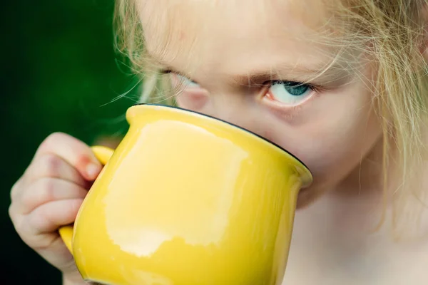 Dziewczyna coś pije. Woda, sok lub mleko. Szczęśliwe chwile. Beztroskie dziecko. — Zdjęcie stockowe