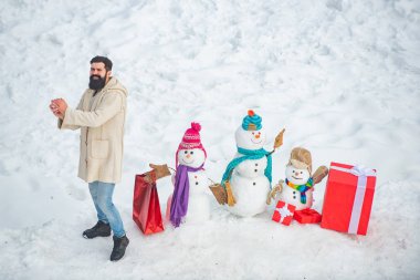 Noel Baba mutlu Noeller diliyor. Noel hediyesi kutulu moda adamı. Komik Noel Baba kışın kırmızı hediye kutusuyla poz veriyor..