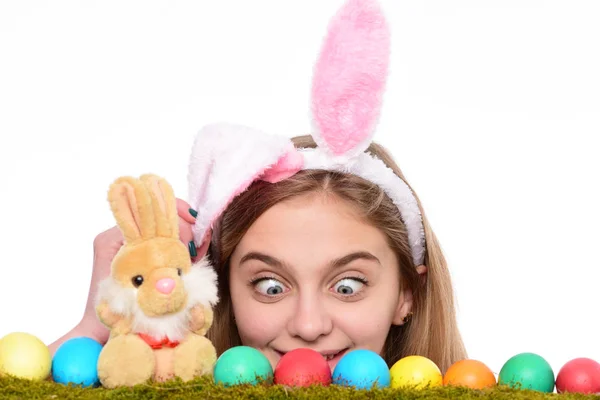 Chica sorprendida usar orejas de conejo en el día de Pascua. Mujer joven con huevos pintados en hierba verde, primavera. Feliz concepto de Pascua. Linda chica con huevos de Pascua decorados aislados en el fondo blanco . —  Fotos de Stock