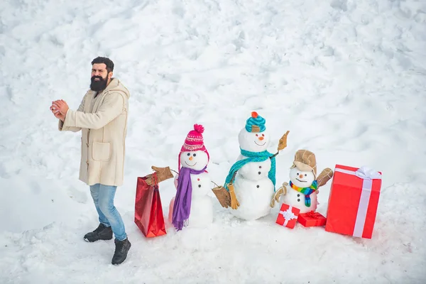 Papá Noel desea feliz Navidad. Hombre de moda con caja regalo de Navidad. Hombre divertido de Santa posando con caja de regalo roja en el clima de invierno. — Foto de Stock