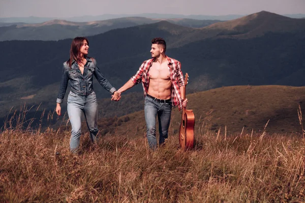 Pareja joven de pie en el camping, hablando y disfrutando de la hermosa naturaleza mientras viaja por las montañas . — Foto de Stock