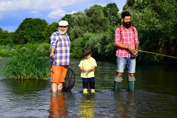 祖父、父亲和孙子一起钓鱼。 爷爷和爷爷在湖边钓鱼。 父亲、儿子和祖父钓鱼. — 图库照片