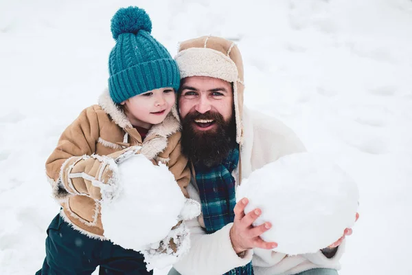 Vánoční pozadí. Den díkůvzdání a Vánoce. Šťastný zimní čas. Otec a syn dělat sněhové koule na zimním bílém pozadí. — Stock fotografie