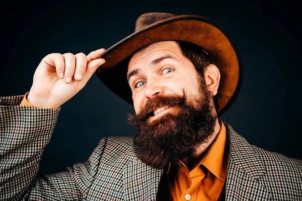 Handsome bearded polite man is happy to see someone. Men style and manners concept. Cheerful smiling gentleman takes off hat in salutation isolated at black background.