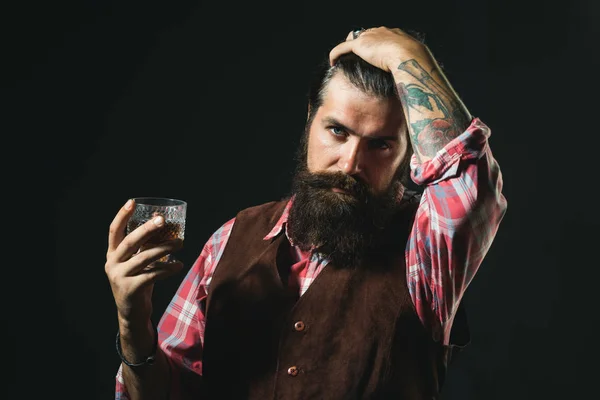 Vousatý obchodník v elegantním obleku se sklenicí whisky. Napít se whisky. Vousatý pohledný muž se sklenicí whisky. — Stock fotografie
