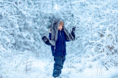 Noel 'den önceki sabah. Kış parkındaki çocuklar. Mutlu Noeller ve mutlu Noeller. Kış parkında dışarıda oynayan tatlı çocuk..
