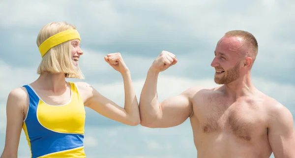 Hermosa chica sonriente compara los músculos con su novio guapo fuerte y divertirse. Sin camisa muscular deportivo hombre y mujer de la piel hacer ejercicios deportivos en el fondo del cielo . —  Fotos de Stock