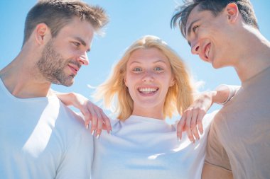 Bir grup neşeli genç erkek ve kadın. Yakışıklı, şık erkekler. Doğal arka plan. İş ekibi. Açık havada bir grup mutlu genç insan. Boş zaman aktivitesi ve arkadaşlık kavramı.