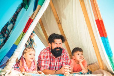 Babalar Günü. Küçük şirin çocuklar mutlu olur ve gülerler. Çatıdaki çocuklar için bir oyun evi ve gökyüzü manzarası. Aileyle eğlenceli bir yaz tatili. Sevgi dolu baba çocuklarla ilgilenir..