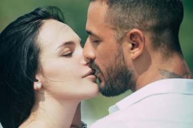Aşık bir çiftin romantik portresi. Nazik romantik çift tüm sevgililerin gününü kutlar. Güzel genç bir çift yüz yüze otururken gülümsüyor..