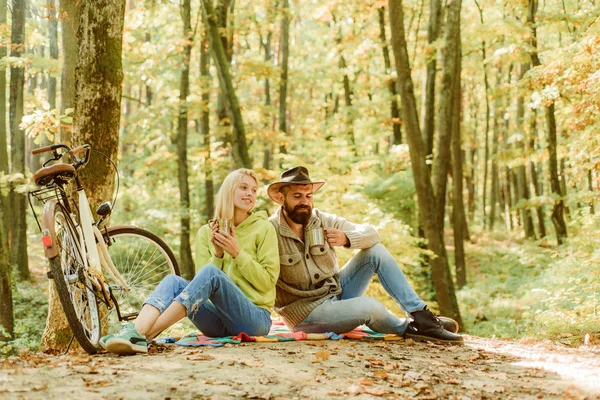 Verliebte Paare beim Picknick im Herbst-Park. Fahrradtour auf der herbstlichen Straße durch den Herbstwald. Hipster Herbst Inspiration. glücklicher Mann und Frau trinken Kaffee und unterhalten sich romantisch. — Stockfoto