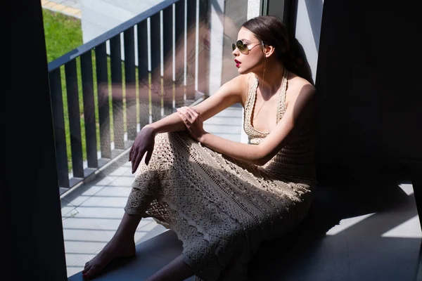 Modelo de moda femenina posando con gafas de sol. Hermosa mujer morena joven con la piel perfecta y el pelo largo y oscuro. Chica modelo sensual con piel lisa y maquillaje. Mujer joven posando . — Foto de Stock