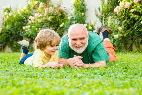 Two generation - weekend together. Retirement parent. Senior man with grandson jogging in park. Family tradition. Happy man family concept laugh and have fun together. — Stock Photo, Image