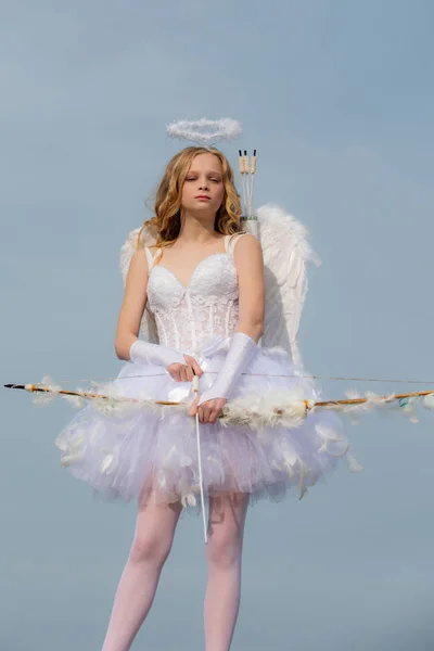 Menina encaracolado encantador em vestido branco e asas - menina cupido anjo. Criança com caráter angelical - conceito de Valentim. Menina adolescente bonita — Fotografia de Stock