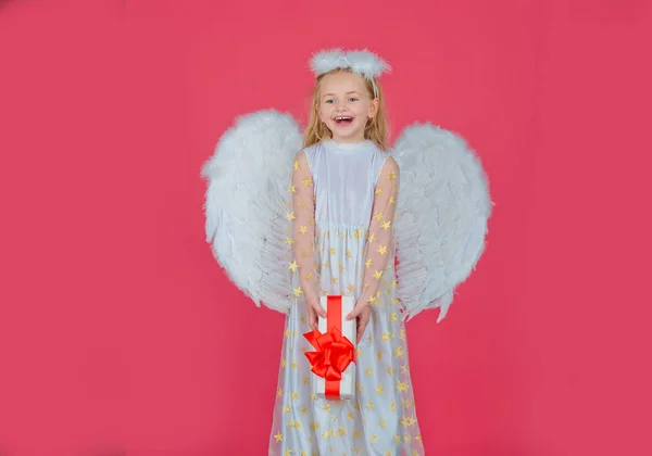 Valentijnsdag. Engelenkind uit de hemel geeft je een geschenk. Portret van een prachtig engelenmeisje met engelenvleugels. Engelenkind. Cherub. Mooi kind engel poseren en kijken naar camera. — Stockfoto