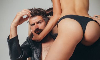 Sigarası olan ciddi bir hippi. Erotik ve ruhani duygular. Rahat ol. Aşk konsepti. Gri arka planda izole edilmiş bir çift portresi. Ticari tasarım. Sakala dokunmak.