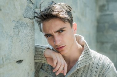 Gri arka planda genç adamın yakın çekimi. Erkek moda konsepti.