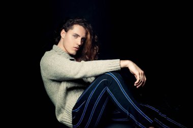 Kendine güvenen ve vahşi bir tarzı olan bir adam. Güzel saç stili olan kendine güvenen bir adamın portresi. Giyim mağazası reklamı. Berber dükkanı reklamı. Siyah arkaplanda izole.