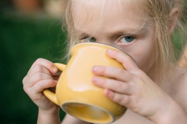 Bir şey içen kız. - Su. Meyve suyu. Süt. Yazın doğada mutlu bir çocuk. Mutlu gün.