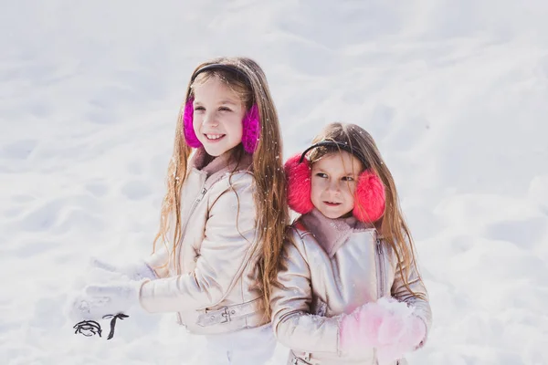 Vêtements d'hiver pour bébé et tout-petit. Joyeux hiver. Des enfants dans la neige. Deux adorables jeunes filles s'amusent ensemble dans un magnifique parc d'hiver . — Photo