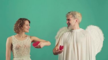 Sevgililer Günü 'nün Gerçek Tarihi. En iyi sevgililer günü fikirleri. Sevgililer Günü 'nde genç bir çift kalp veriyor. Güzel çift öpüşüyor. Sevgililer Günü. Yeşilde izole edilmiş.