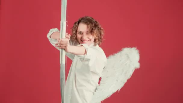 爱的概念。 一个带着弓箭的可爱的天使女人 情人节人的概念。 天使女孩，弓箭覆盖粉红背景，与粉红背景隔离. — 图库视频影像