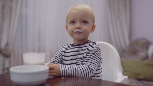 Mignon nourrisson manger. Bébé heureux manger du porridge avec cuillère . — Video