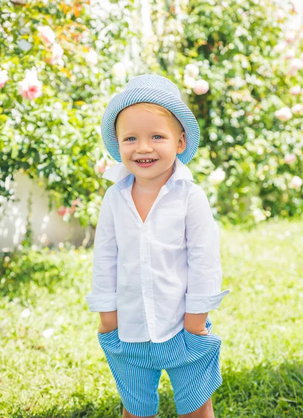 Kinderopvang. Jongen schattig speels vrolijk kind grappig grimas gezicht. Portret van een vrolijk lachend kind op de achtergrond van de natuur. — Stockfoto