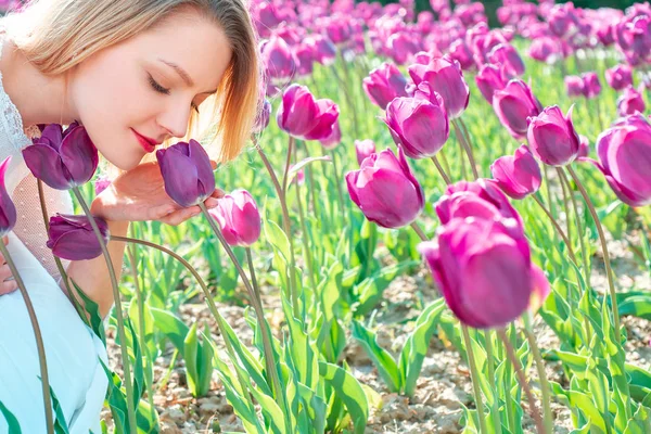 La idea y el concepto de mujeres felices en el Día Internacional de la Mujer. Mujer joven relajándose en los campos de tulipanes . —  Fotos de Stock