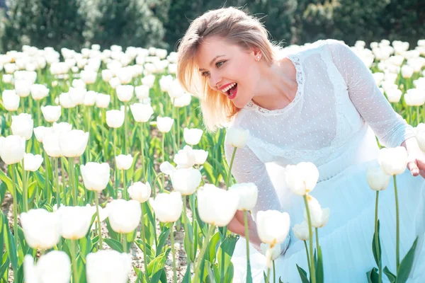 Dziewczyna na polu białych tulipanów uśmiechnięta. Pole kolorowych jasnoczerwonych tulipanów. — Zdjęcie stockowe