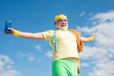 Kıdemli sporcular için enerji dolu. Sağlık kulübünde kıdemli adam. Yaşlı sporcular için enerjiktir. Spor gibi. Yaşlı adam mavi gökyüzü arka planında spor yapıyor.
