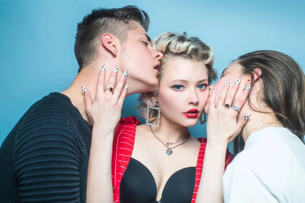 Vrouw en man zoenen meisje op wangen. Liefde driehoek concept. Relaties communicatie vriendschap liefde. Een close-up van twee jonge vrouwen en een knappe mannelijke kus. Jonge dames en mannen in de studio. — Stockfoto