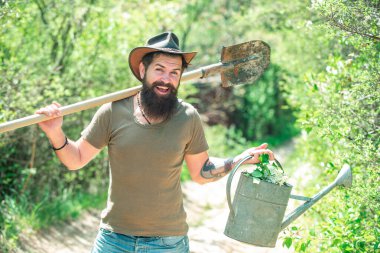 Aletleri olan bahçıvan. Kürek ve sulama tenekeli mutlu çiftçi. Kırsalda geçirdiğimiz zamanları seviyorum. Dünya günü. Yaz çiftçiliği.