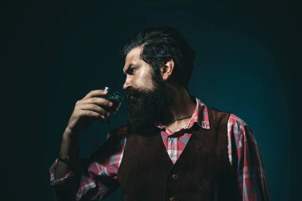 Concepto de bebidas de lujo. Elegante hombre rico sosteniendo un vaso de whisky viejo. Empresario barbudo en traje elegante con vaso de whisky . —  Fotos de Stock