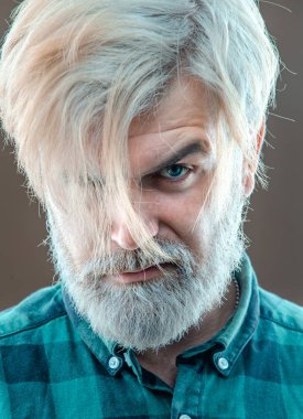 Gri arkaplandaki modaya uygun Latin adamın yüzünü kapatın. Stüdyoda sakallı ve modern saç stili olan adam..