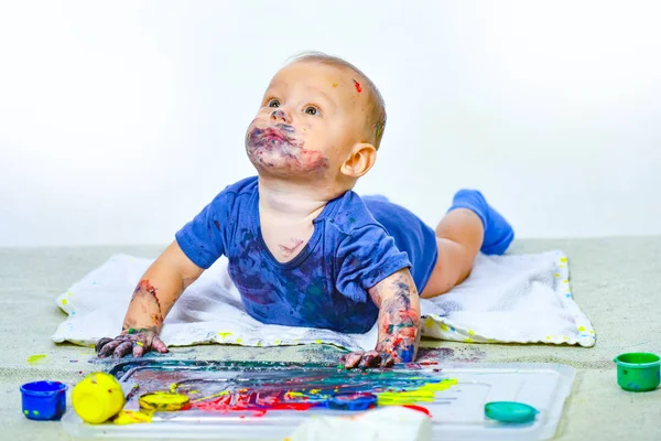 A baba festékekkel játszik. Gyönyörű boldog gyermek. Életmód gyermekkori koncepció. Kicsi babafesték a kezénél. Aranyos kölyök. Baba portré fehér háttér. — Stock Fotó