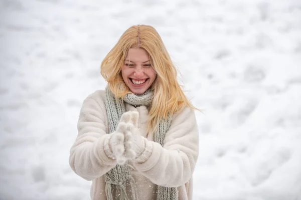 Χειμερινή γυναίκα. Κορίτσι που παίζει με το χιόνι ρίχνει μια μπάλα στις χειμερινές διακοπές. Πορτραίτο μιας ευτυχισμένης γυναίκας το χειμώνα. Χαρούμενο κορίτσι έξω.. — Φωτογραφία Αρχείου