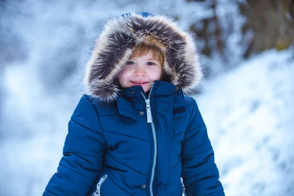 Des gens dans la neige. Loisirs pour enfants d'hiver. Les enfants s'amusent dans le champ de neige blanche contre les arbres enneigés. Enfant joyeux s'amusant dans le parc d'hiver . — Photo
