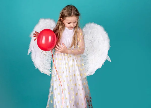 Valentinstag der Kinder. Gesicht der schönen kleinen Engelmädchen auf farbigem Hintergrund. hübsches kleines Engelmädchen. Kind mit Engelsgesicht. Kind mit langem weißen Kleid und Engelsflügeln. — Stockfoto