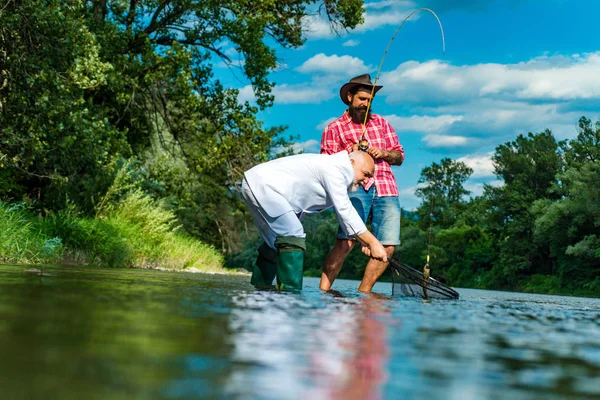 Ψαράς με επίσημο κουστούμι. Πορτρέτο δύο ανδρών σε διακοπές. Άνδρες χαλαρωτικό φόντο της φύσης. Πιάσιμο και ψάρεμα. Ενωμένοι με τη φύση. Έτοιμος για ψάρεμα. Κομψός γενειοφόρος ψαρεύει. Χόμπι του επιχειρηματία. — Φωτογραφία Αρχείου