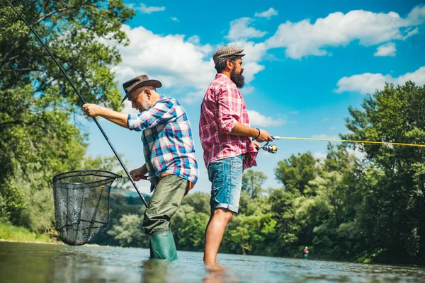 Volwassen man met vriend vissen. Een baardvisser in het water. Maak met inspiratie. Mannen baardvissers. Volwassen man vissen op de vijver. Ontspan in een natuurlijke omgeving. Thuis van hobby 's. Visserij. — Stockfoto