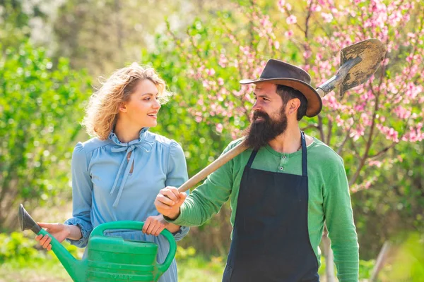 春の季節に庭で幸せなカップルの肖像画。農業と農業栽培。農場の新鮮な有機野菜. — ストック写真