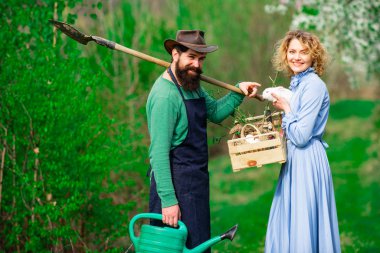 Bir çift çiftçi tarlada yürüyor. Bahçede filizlenen iki çiftçi..