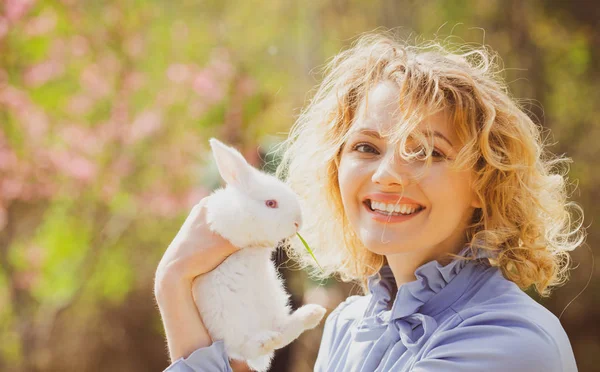Drôle de lapin de Pâques. Belle jeune femme avec lapin à la ferme. Portrait de jeune femme posant avec le lapin . — Photo