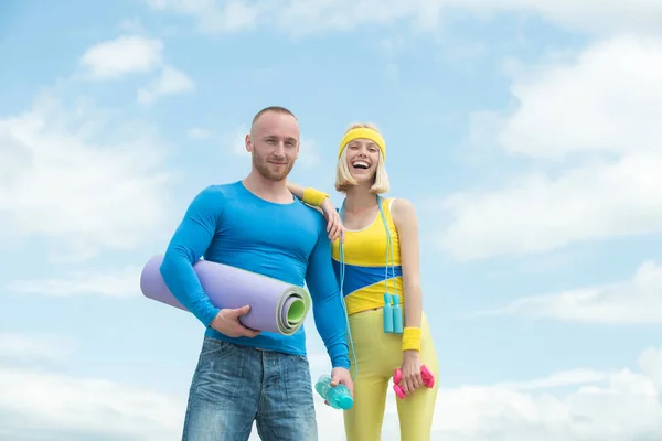 A szerető pár fitnesz edzést tart a szabadban. Sikeres csapatmunka a kék ég hátterében. Gyönyörű vidám mosolygós nő edzés a sport edző. — Stock Fotó