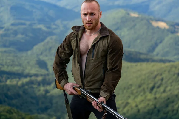 Fusiles de caza americanos. Hombre con un arma. Hombre cazador guapo sosteniendo arma y caminando en el bosque. Temporada de caza de otoño . —  Fotos de Stock