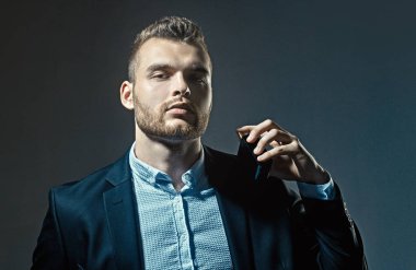 Parfüm lüzfünü. Bir şişe parfümeri tutan adam. Mans parfüm konsepti. Erkekparfüm.
